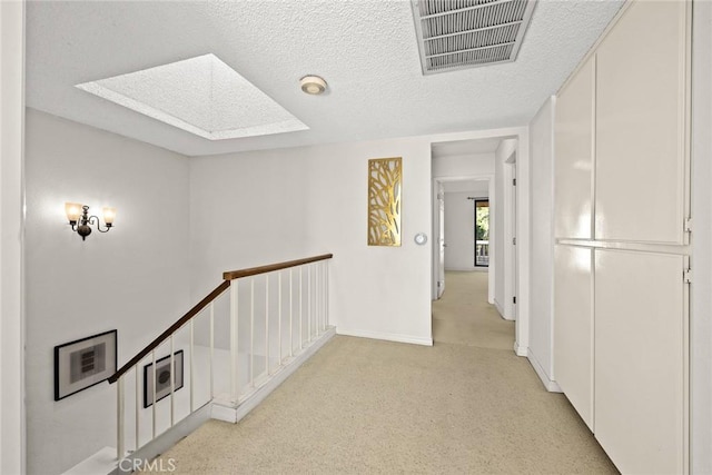 1824 S Marengo Ave Unit 27, Alhambra, CA 91803 - hall with light colored carpet, a skylight, an upstairs landing, baseboards, and a textured ceiling