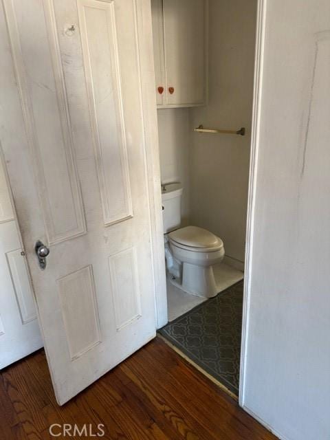 bathroom featuring toilet and wood-type flooring