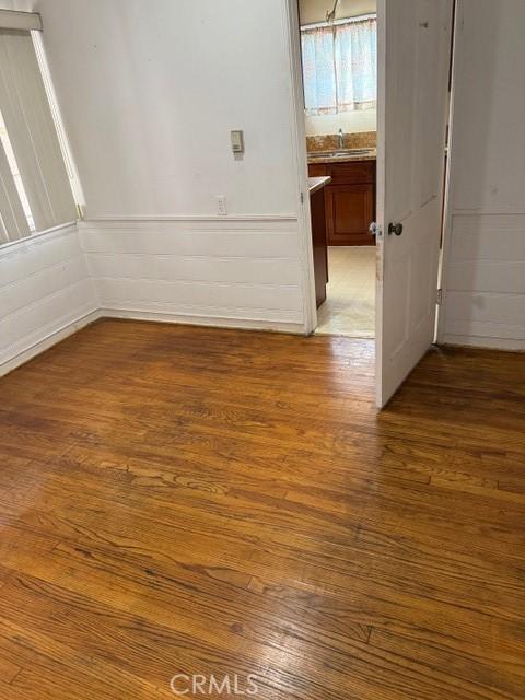 spare room with hardwood / wood-style flooring and sink