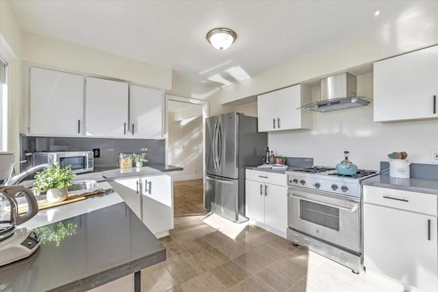 kitchen featuring wall chimney exhaust hood, appliances with stainless steel finishes, sink, and white cabinets