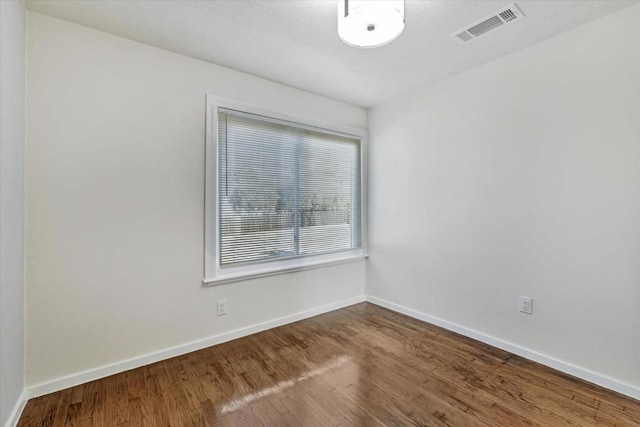 unfurnished room with wood-type flooring