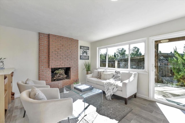 living room featuring a brick fireplace and light hardwood / wood-style floors