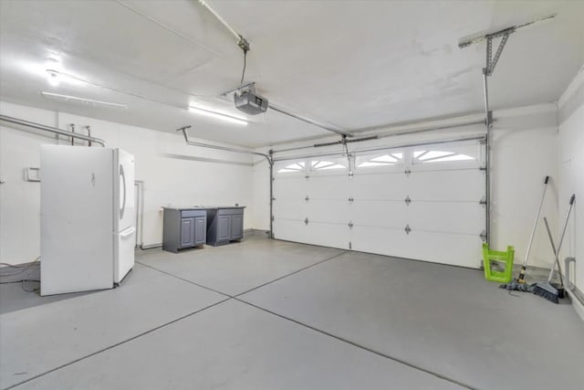 garage with a garage door opener and white fridge