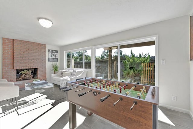 recreation room featuring a brick fireplace