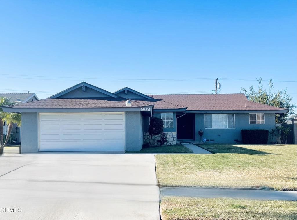 ranch-style home featuring a garage and a front lawn