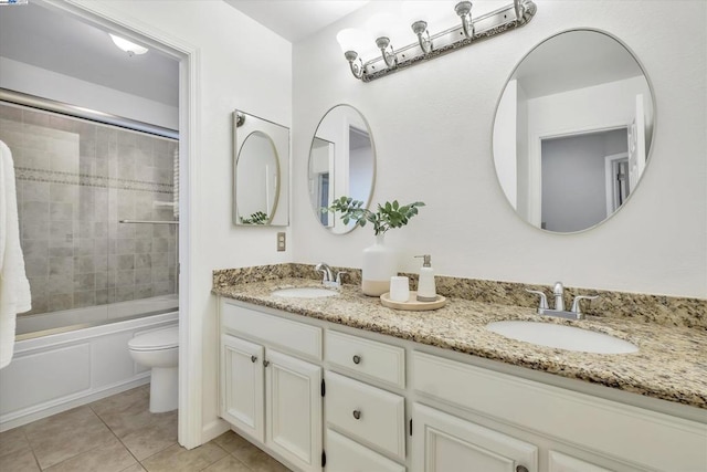 full bathroom with vanity, toilet, bath / shower combo with glass door, and tile patterned flooring