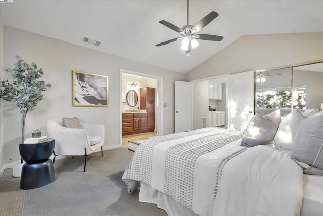 bedroom featuring ceiling fan, carpet, lofted ceiling, and ensuite bath