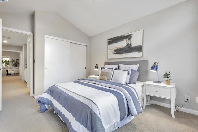 bedroom featuring a closet, vaulted ceiling, and light carpet