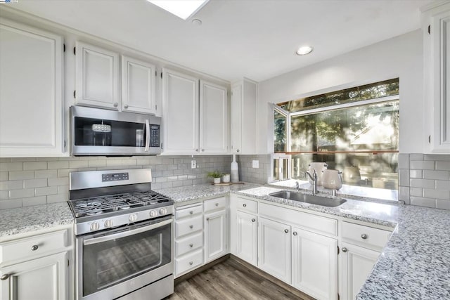 kitchen featuring backsplash, white cabinets, and appliances with stainless steel finishes