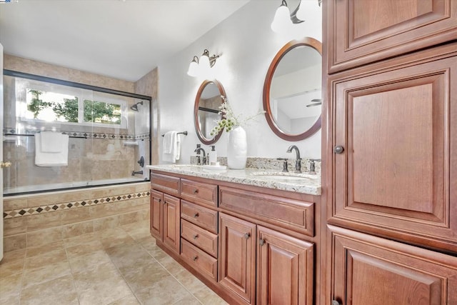 bathroom featuring a shower with door and vanity