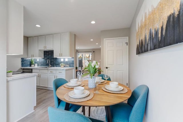 dining area featuring sink and light hardwood / wood-style flooring