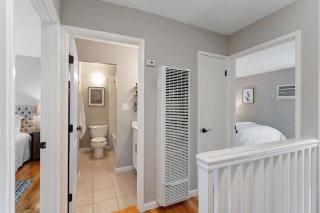 bathroom with toilet, vanity, tile patterned flooring, and a wall unit AC