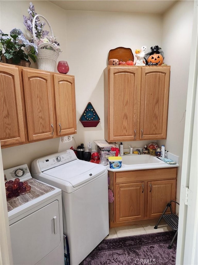 laundry area featuring independent washer and dryer, cabinets, dark tile patterned flooring, and sink