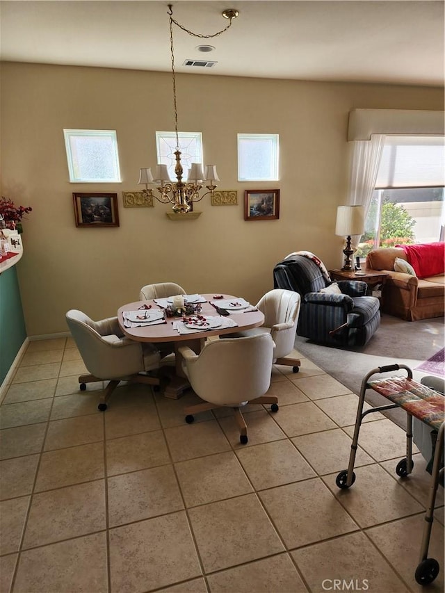 dining area featuring a notable chandelier and light tile patterned flooring