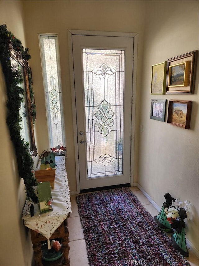 doorway to outside featuring light tile patterned floors and a wealth of natural light