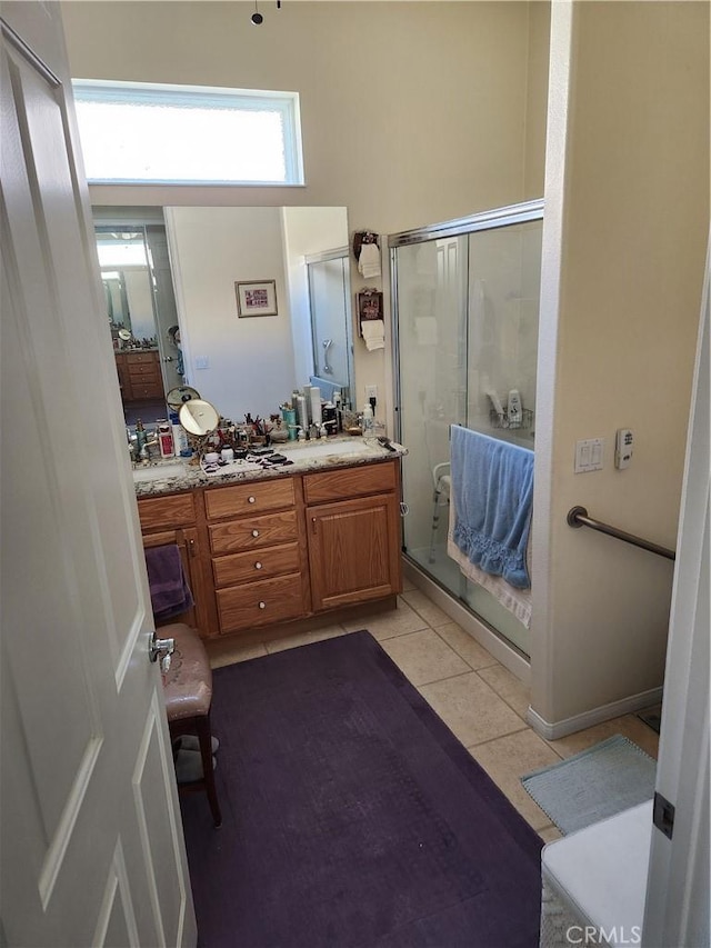 bathroom with walk in shower, vanity, and tile patterned floors