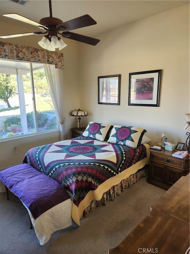 carpeted bedroom featuring multiple windows and ceiling fan