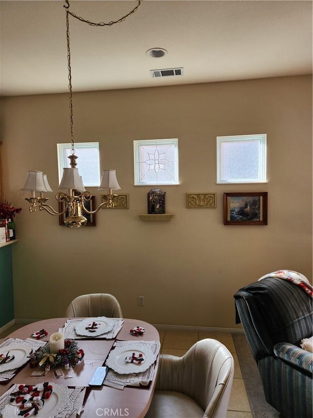 unfurnished dining area with a notable chandelier and tile patterned flooring