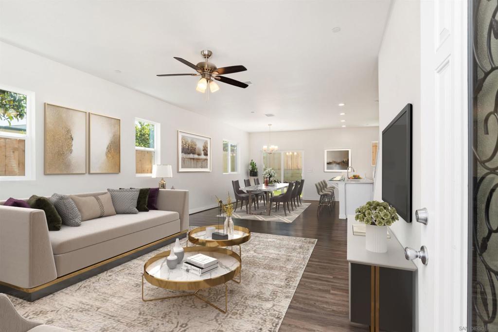 living room with ceiling fan with notable chandelier, dark hardwood / wood-style flooring, and plenty of natural light