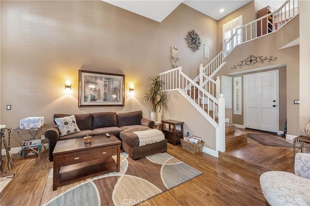 living room with a high ceiling and hardwood / wood-style flooring