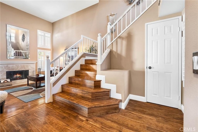 staircase with a high end fireplace and hardwood / wood-style flooring