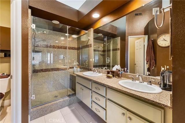 bathroom featuring toilet, tile patterned flooring, a shower with door, and vanity