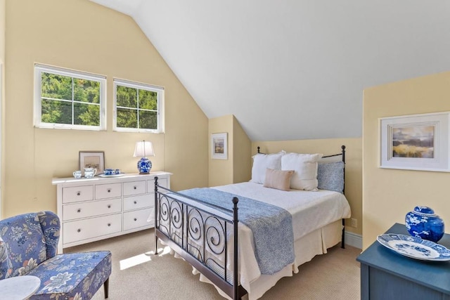 bedroom with lofted ceiling and light colored carpet