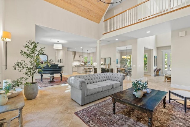 living room featuring an inviting chandelier, wooden ceiling, and high vaulted ceiling