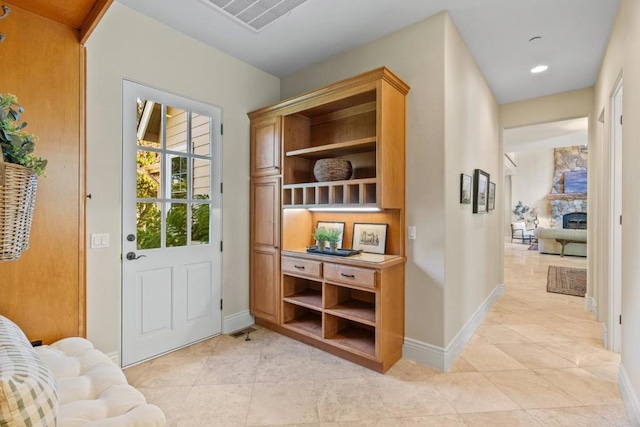 entryway featuring a stone fireplace