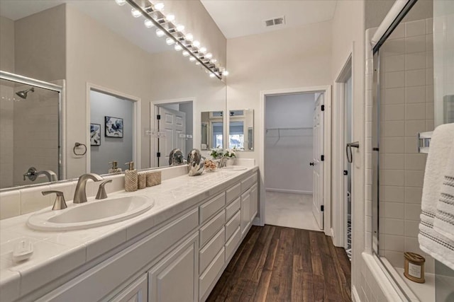 bathroom featuring vanity, hardwood / wood-style floors, and a shower with shower door