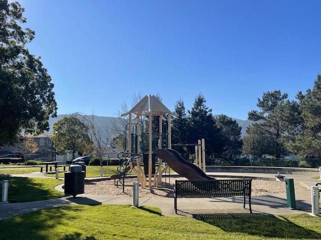 view of play area featuring a mountain view and a yard