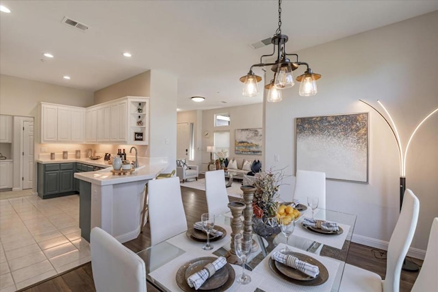 dining room featuring light tile patterned flooring, a chandelier, and sink