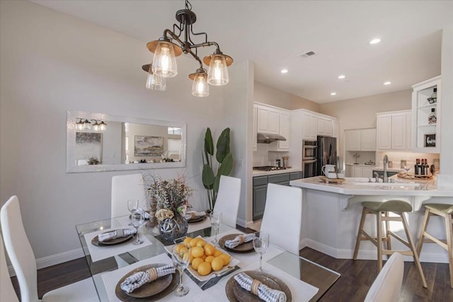 dining area featuring sink and dark hardwood / wood-style flooring