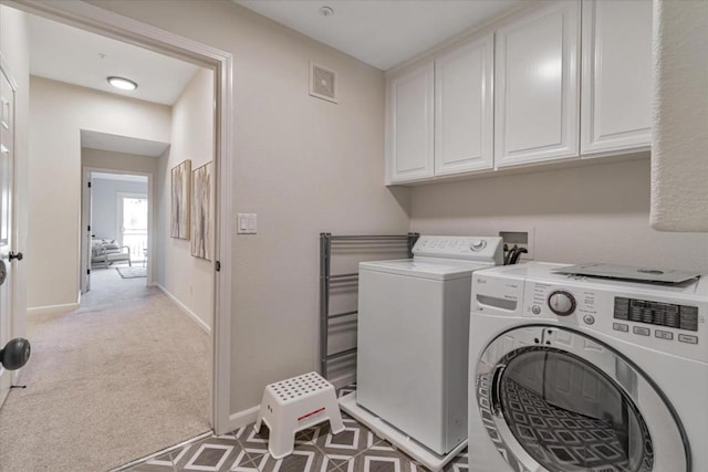 washroom with independent washer and dryer, light colored carpet, and cabinets