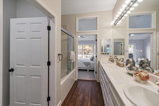 bathroom with vanity, hardwood / wood-style floors, and bath / shower combo with glass door