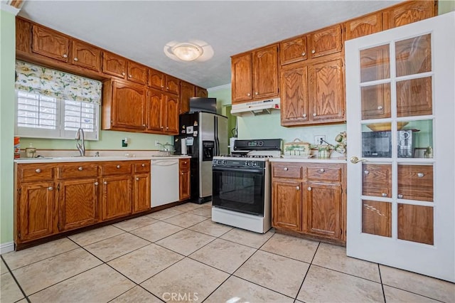 kitchen featuring white appliances, sink, and light tile patterned floors