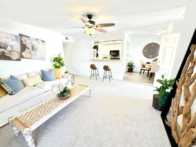 living room featuring ceiling fan and carpet floors