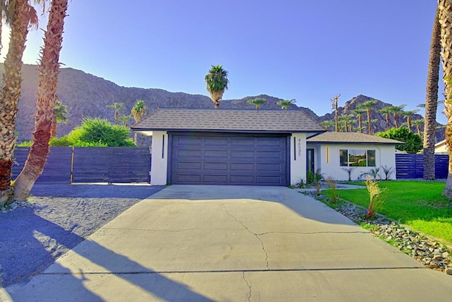 view of front of property with a front lawn, a garage, and a mountain view