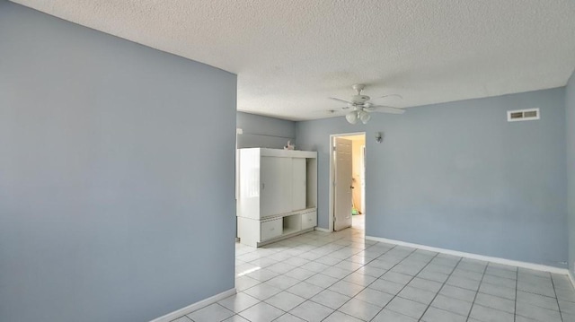 tiled spare room with ceiling fan and a textured ceiling