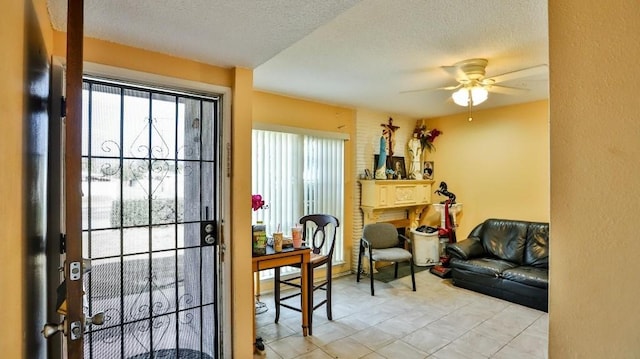 doorway featuring ceiling fan and a textured ceiling