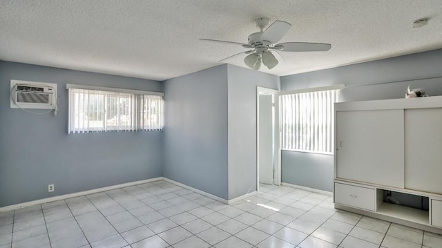 spare room with ceiling fan, a textured ceiling, and a wall unit AC