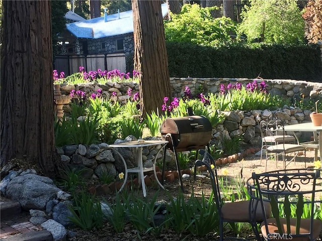 view of yard with a small pond, fence, and a patio