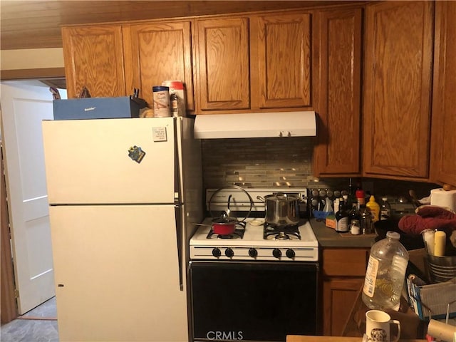 kitchen featuring brown cabinetry, ventilation hood, and white appliances