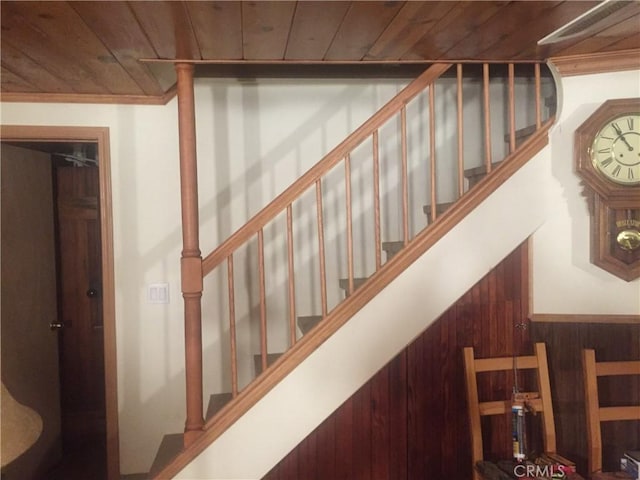 staircase featuring wood walls and wood ceiling