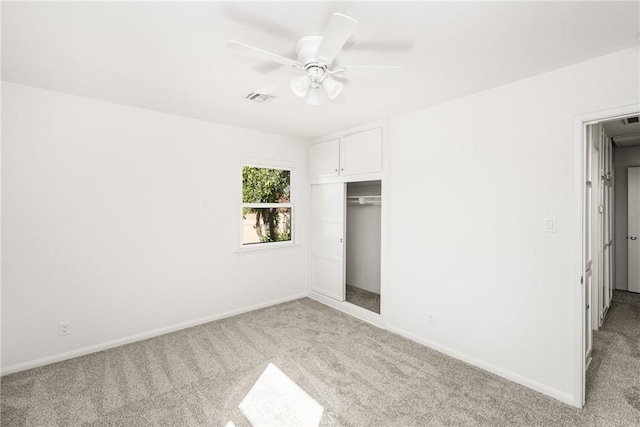 unfurnished bedroom featuring ceiling fan, a closet, and light carpet