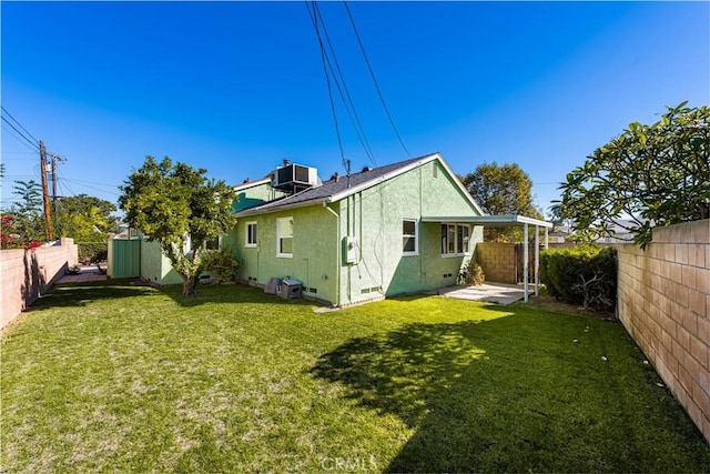 back of house featuring central AC unit and a lawn