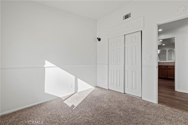 unfurnished bedroom with a closet and carpet flooring