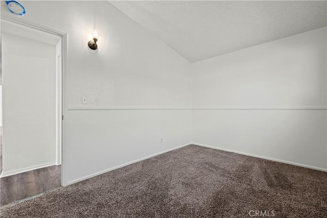 spare room featuring lofted ceiling and carpet flooring