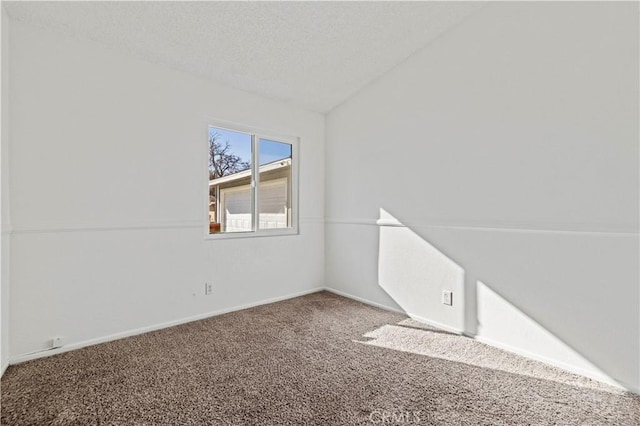 carpeted empty room with lofted ceiling and a textured ceiling