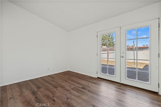 empty room featuring french doors, lofted ceiling, and dark hardwood / wood-style floors